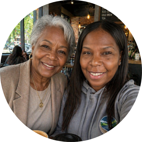 An older woman and her companion smiling together in a café